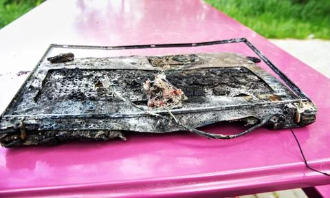 Broken laptop computer spoiled by flame of hot fire. Stock Photos
