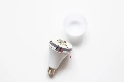A broken LED light bulb on a white background, depicting breakdowns, power .. Stock Photos