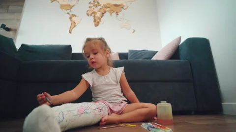 broken leg. A little girl paints on a pl... | Stock Video | Pond5