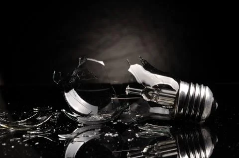 Broken light bulb on black background Stock Photos
