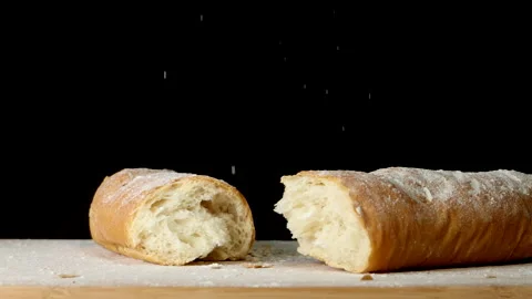 Broken loaves of bread on a wooden board covered with flour Stock Footage 201285960