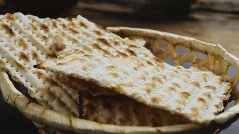 A broken matzah in a bread basket on the table rotates in a circle Stock Footage 241940476