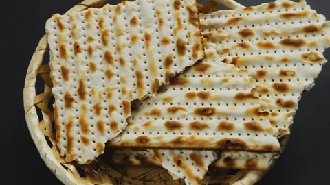 A broken matzah in a bread basket on the table rotates in a circle. Stock Footage 242286723