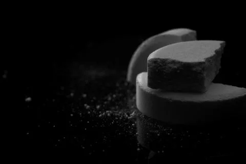Broken medication tablets and powder on black background Stock Photos