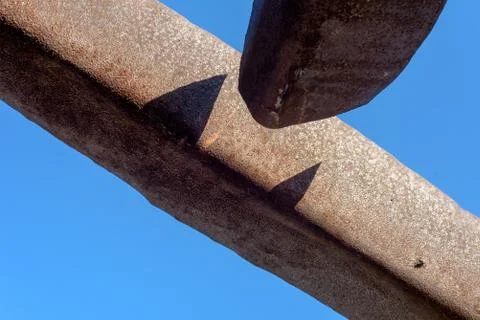 Broken metal gutter that is disconnected set against a blue sky Stock Photos