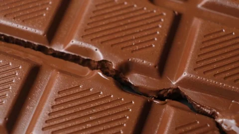 Broken milk chocolate bar rotating slowly. Top view vertical video. Stock Footage 345640014