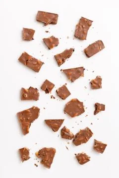 Broken milk chocolate pattern, top view flat lay on background Stock Photos