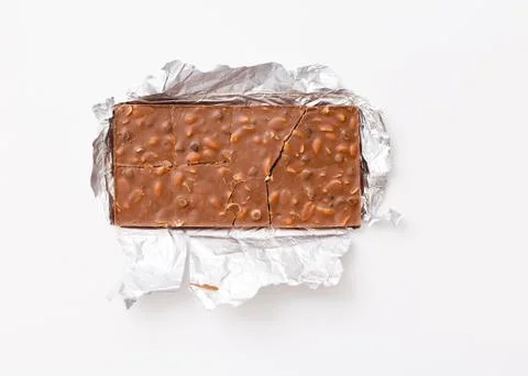 Broken milk chocolate pattern, top view flat lay on background Stock Photos