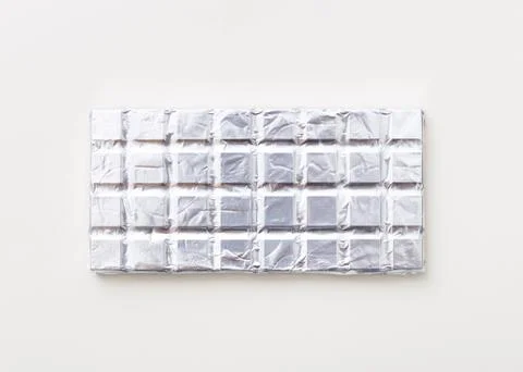 Broken milk chocolate pattern, top view flat lay on background Stock Photos