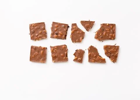 Broken milk chocolate pattern, top view flat lay on background Stock Photos