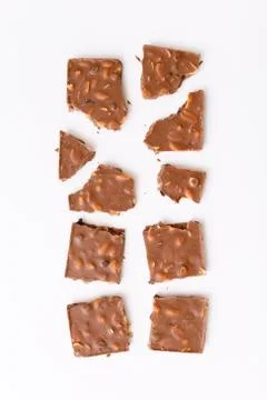 Broken milk chocolate pattern, top view flat lay on background Stock Photos