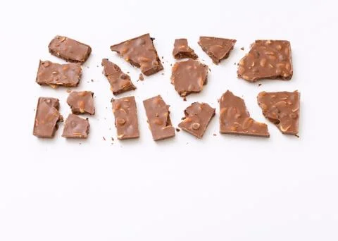 Broken milk chocolate pattern, top view flat lay on background Stock Photos