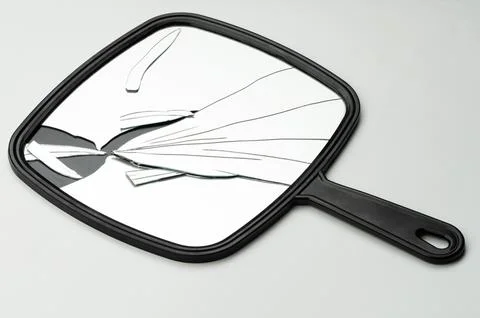 Broken mirror with reflection on plain background Stock Photos