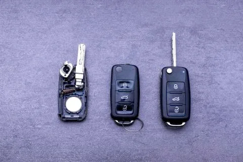 Broken or damaged remote key fob and new vehicle key on gray background. Brok Stock Photos