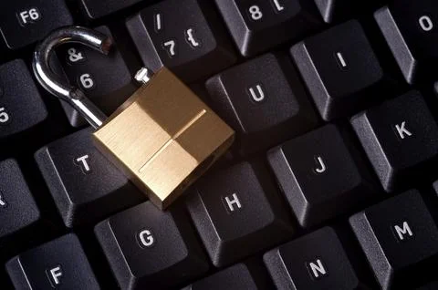 A broken padlock on top a computer keyboard to represent the concept of computer 스톡 사진