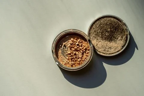 Broken palette with bronzer on a white table. Decorative cosmetics Foto stock
