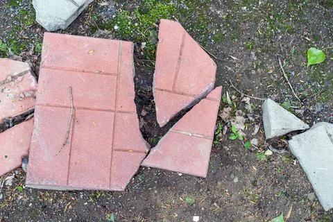 Broken paving slabs on the footpath. Stock Photos