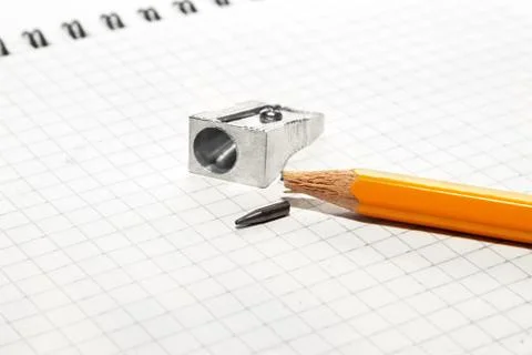 Broken pencil and sharpener on a notebook Stock Photos