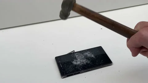 Broken phone. Hammer hitting the display breaks the mobile phone Stock Footage 221140878