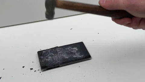 Broken phone. Hammer hitting the display breaks the mobile phone Stock Footage 221141088