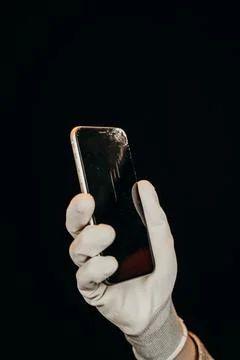 A broken phone screen in the hands of a master in a white glove Stock Photos