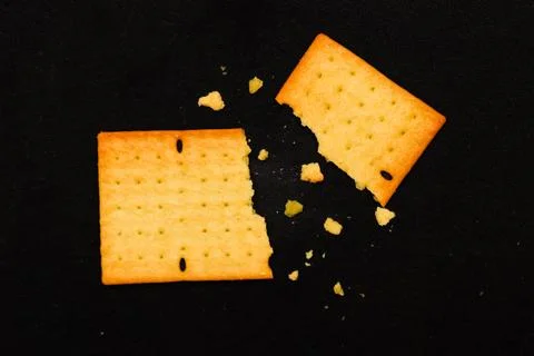 Broken Pieces of Crispy Wheat Cracker with Crumbs on Black Background, Clos.. Fotos de archivo
