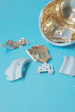 Broken pieces of a decorative object on a blue table Stock Photos