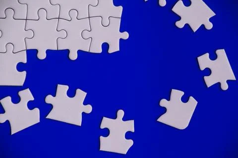 Broken pieces of jigsaw puzzles on blue background. Foto stock
