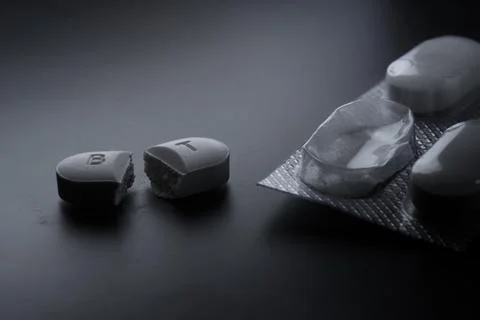 Broken pill and empty blister pack symbolizing addiction 스톡 사진
