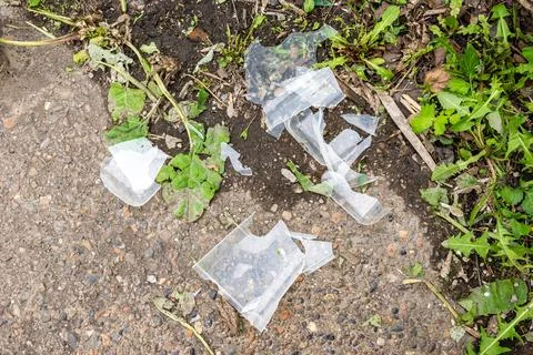 Broken plastic fragments on soil surface Stock Photos