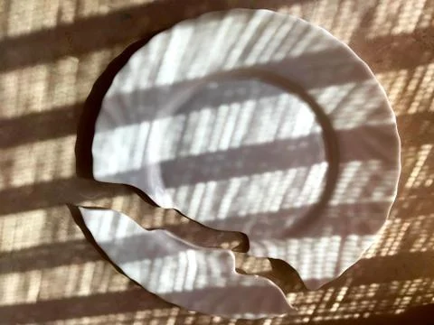 Broken plate on the table, on the floor. Stock Photos