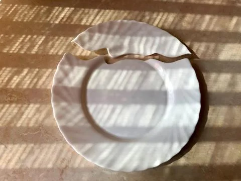 Broken plate on the table, on the floor. Stock Photos