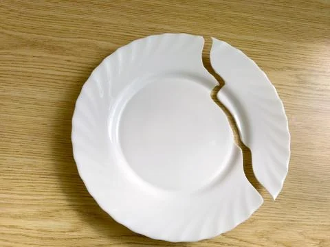 Broken plate on the table, on the floor. Stock Photos