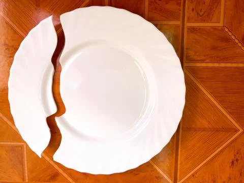 Broken plate on the table, on the floor. Stock Photos