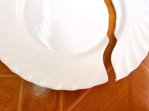 Broken plate on the table, on the floor. Stock Photos
