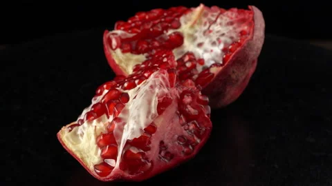 Broken pomegranate fruit close up on black background Stock Footage 141283075