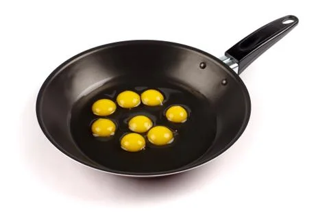 Broken quail eggs in pan Stock Photos