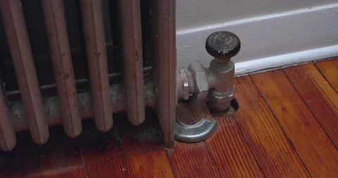 Broken Radiator pipe valve connection to wood floor in apartment / home / condo Stock Footage 239935735
