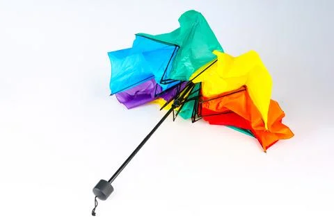 Broken rainbow umbrella damaged by wind on white background Stock Photos
