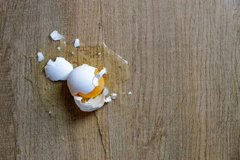 Broken Raw Egg with Cracked White Shell on a Rustic Wooden Table Surface Stock-Fotos
