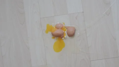Broken raw egg spilled on a wooden parquet floor Stock Footage 342024814