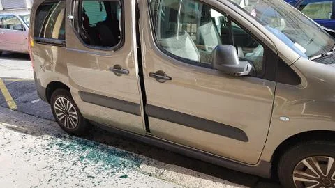 Broken rear side window of a car by thief with broken glass on the floor. Thief Stock Photos