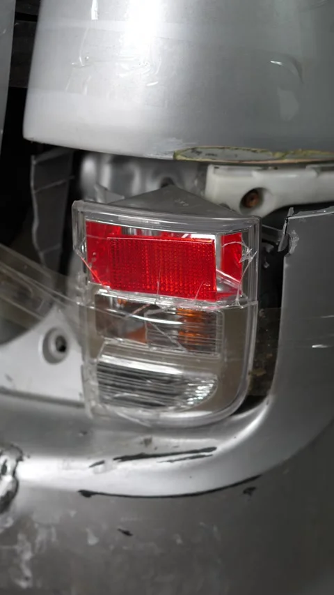 Broken red car taillight with cracks covered in transparent tape. Stock Footage 343888904