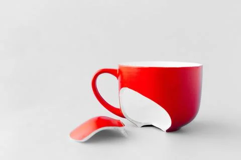 Broken red cup on blue background, symbol of divorce, loss Stock Photos