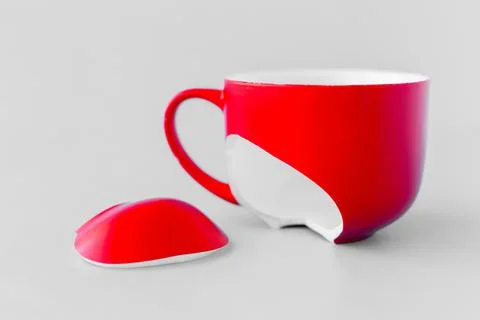 Broken red cup on blue background, symbol of divorce, loss Stock Photos
