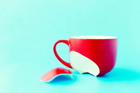 Broken red cup on blue background, symbol of divorce, loss Stock Photos
