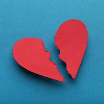 Broken red heart on blue background for love or sadness Stock Photos