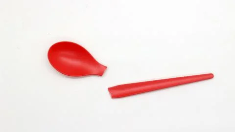 Broken red plastic spoon isolated Foto stock