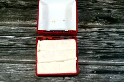 A broken red velvet presentation box, typically used for storing, or presen.. Stock Photos