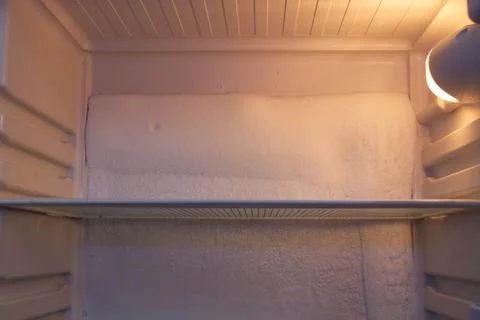 Broken refrigerator with snow inside need repairing. Icing on the back wall Stock Photos